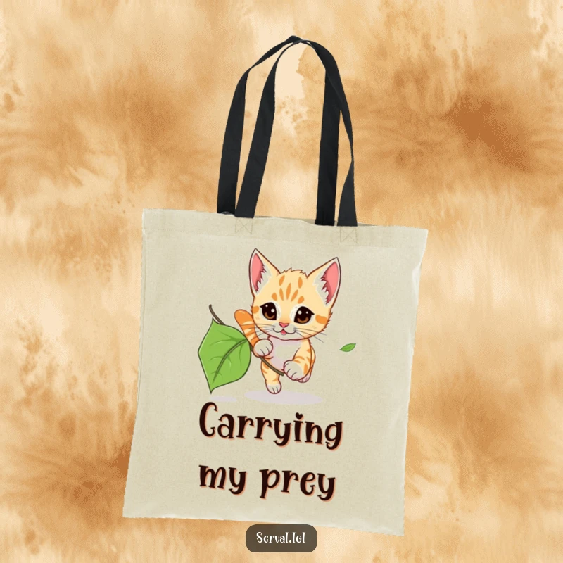 Funny Serval Kitten Leaf Chase Tote Bag: A tote bag with a serval kitten playfully chasing a leaf, perfect for everyday adventures.