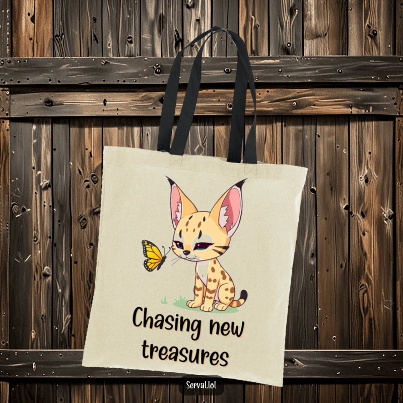Funny tote bag featuring a serval stalking a butterfly, a humorous accessory for cat lovers and nature fans.